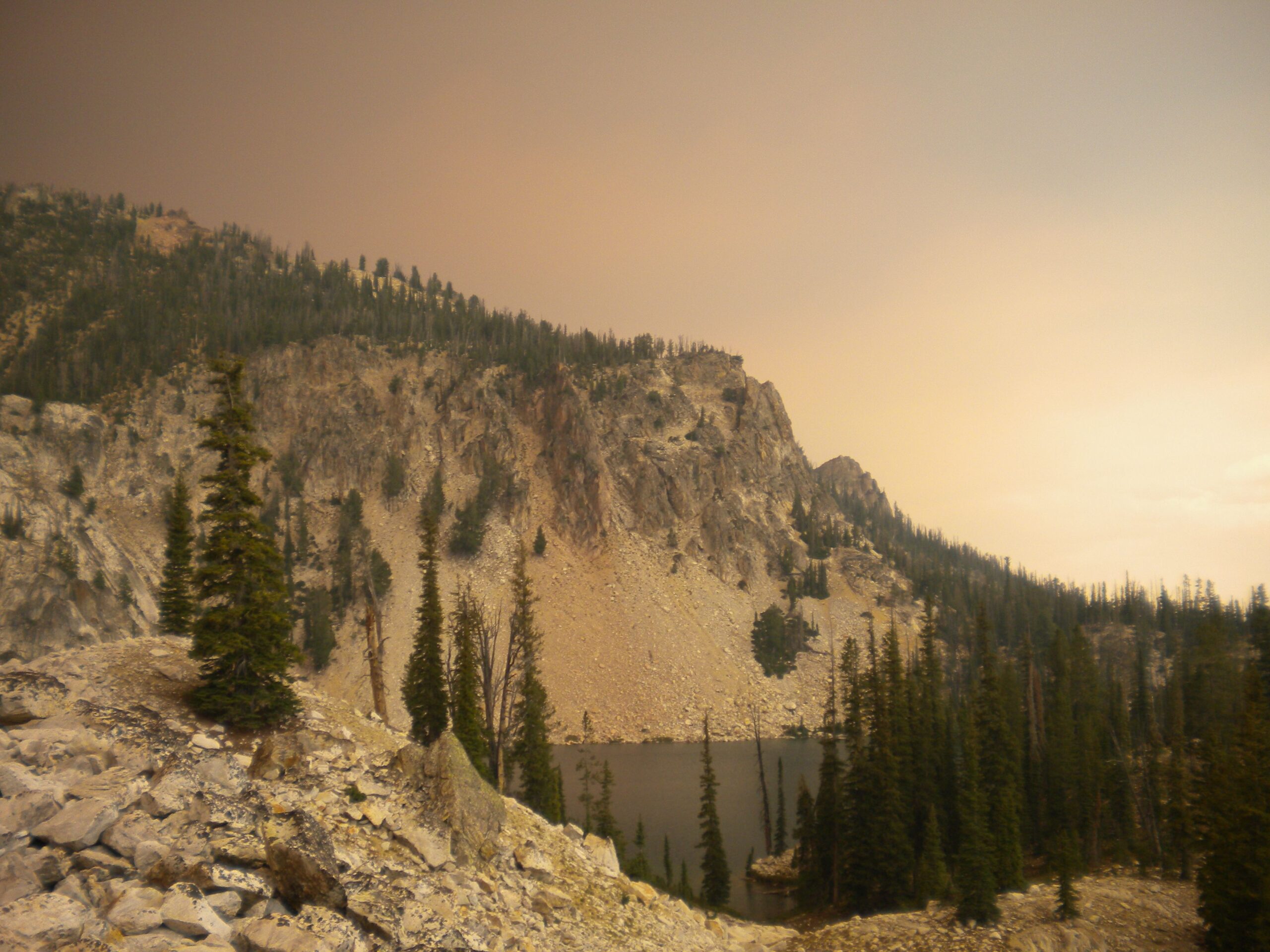 alpine lake near Stanley, Idaho; smoke and ash in sky create a surreal atmosphere