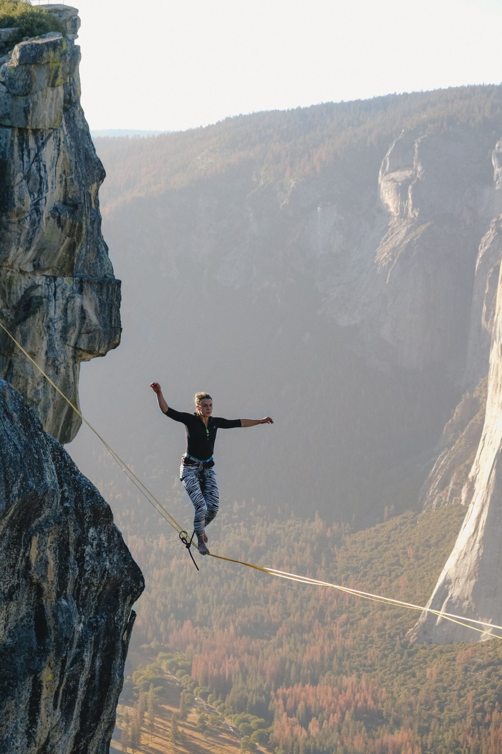 person walking a tightrope over a deep canyon